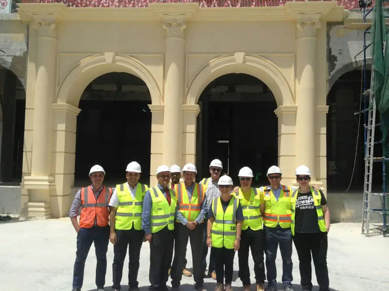 Employees in hard hats outside building with columns